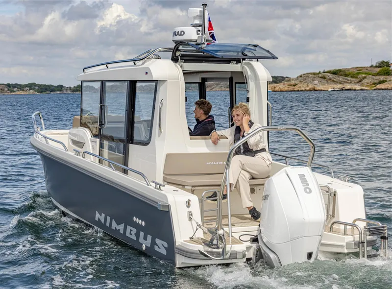 Slide: The Image of 2025 Nimbus C8 boat cruising on open water with two passengers onboard. - 10