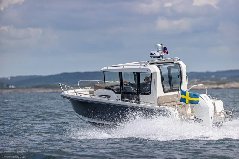 Slide: The Image of Nimbus C8 2025 boat cruising on open water with Swedish flag. - 29