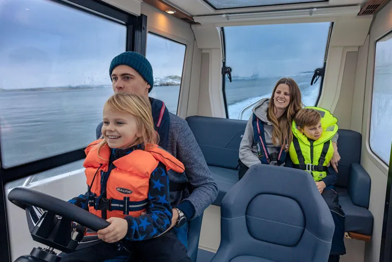 Slide: The Image of Family enjoying a ride on a 2025 Nimbus C8 boat. - 5