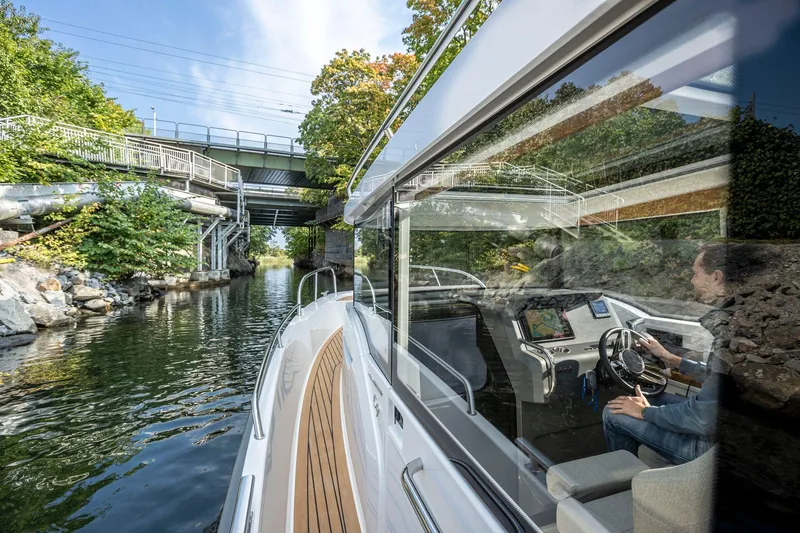 Slide: The Image of Nimbus C9 boat navigating a narrow waterway under a bridge, 2025 model. - 22