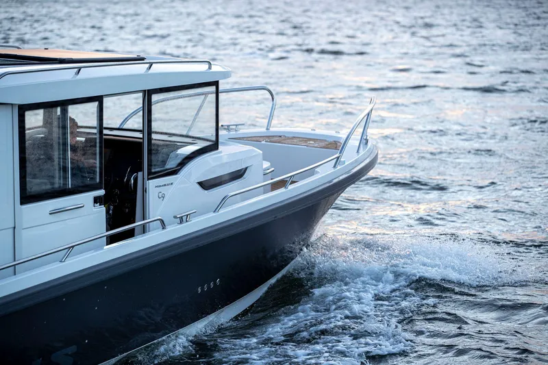 Slide: The Image of Nimbus C9 2025 boat cruising on open water at sunset. - 25