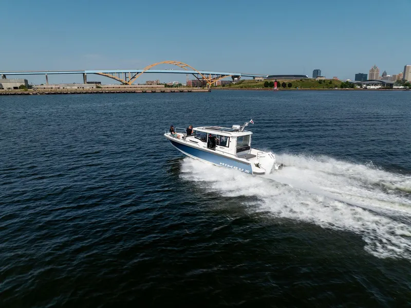 Slide: The Image of Nimbus C9 boat cruising on a sunny day near a bridge, 2025 model. - 10