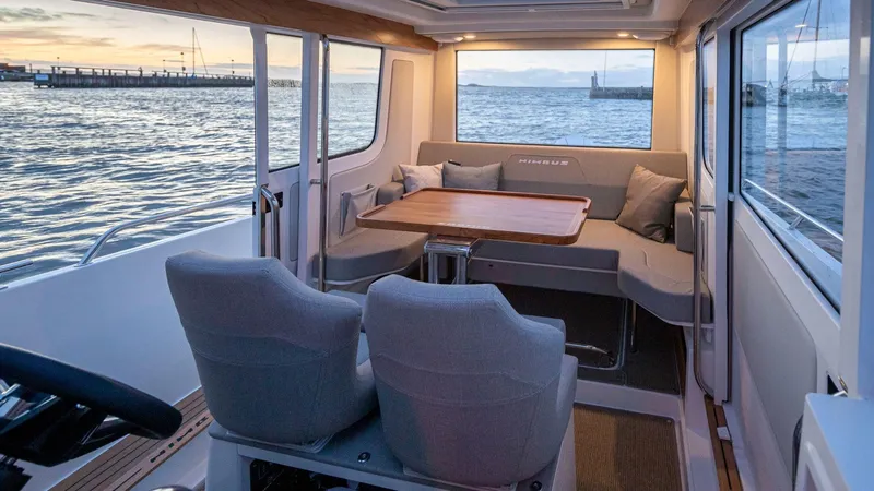 Slide: The Image of Interior of 2025 Nimbus C9 boat with seating and table, overlooking serene waters. - 6