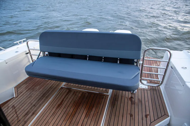 Slide: The Image of Nimbus C11 2025 boat with blue bench seat on teak deck, overlooking water. - 19