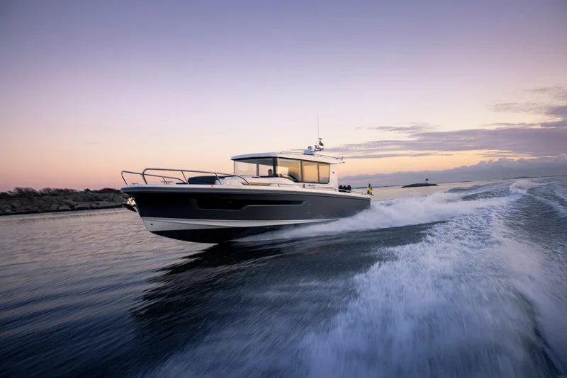 The Image of 2025 Nimbus C11 boat cruising at sunset on open water. - 0