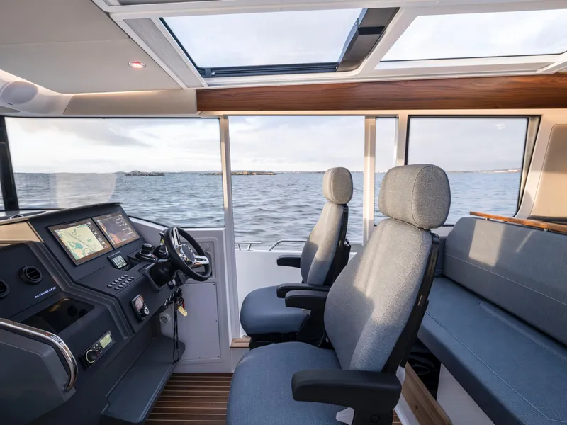 Slide: The Image of Modern Nimbus C11 boat interior with navigation system, plush seating, and panoramic windows, 2025 model. - 12