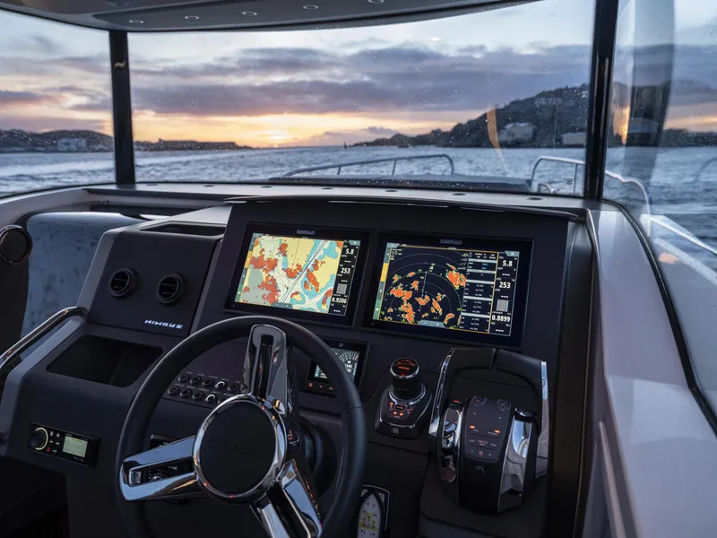 Slide: The Image of Nimbus C11 2025 boat dashboard with navigation screens at sunset on the water. - 21