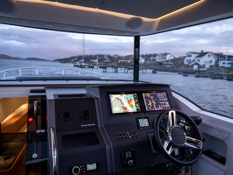 Slide: The Image of Modern Nimbus C11 yacht cockpit with advanced navigation system, 2025 model, overlooking coastal scenery. - 42