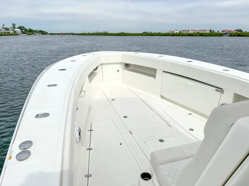Slide: The Image of 2017 SeaVee 390z Center Console boat on calm water, showcasing spacious deck and seating. - 8