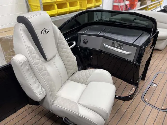 Slide: The Image of 2024 Manitou 25 LX SHP DE boat interior with luxurious seating and dashboard. - 14