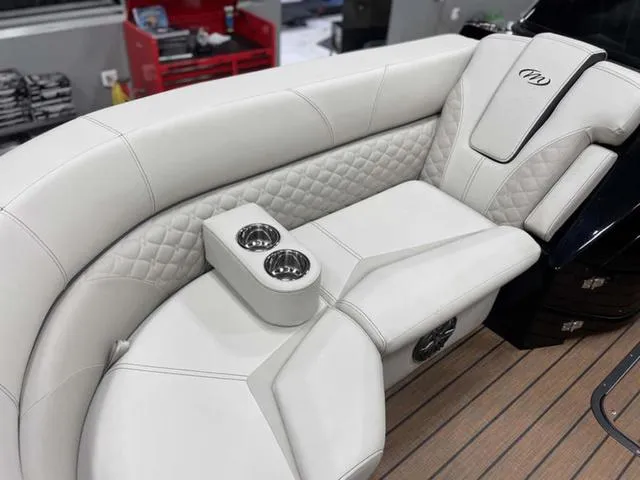 Slide: The Image of Luxurious seating on 2024 Manitou 25 LX SHP DE boat with dual cup holders. - 16