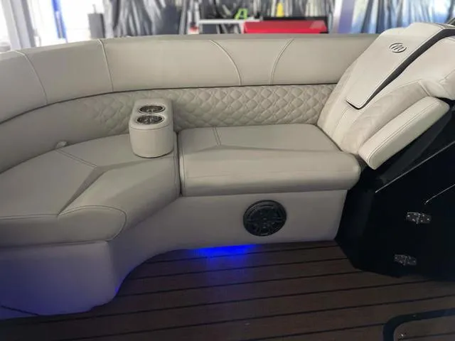Slide: The Image of Luxurious seating on 2024 Manitou 25 LX SHP DE boat with dual cup holders and ambient lighting. - 18