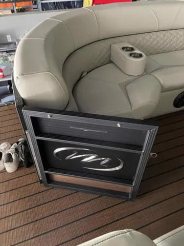 Slide: The Image of 2024 Manitou 25 LX SHP DE boat interior with beige seating and cup holders. - 19