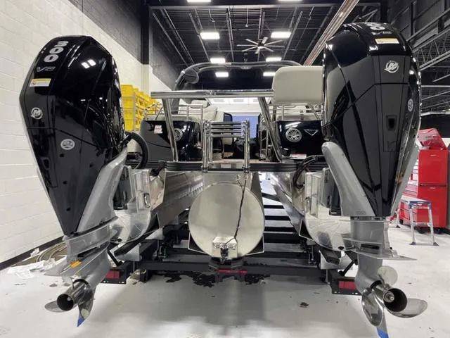 Slide: The Image of 2024 Manitou 25 LX SHP DE pontoon boat with dual engines in a showroom. - 4