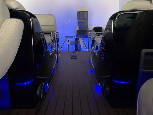 Slide: The Image of 2024 Manitou 25 LX SHP DE boat interior with blue LED lighting. - 8