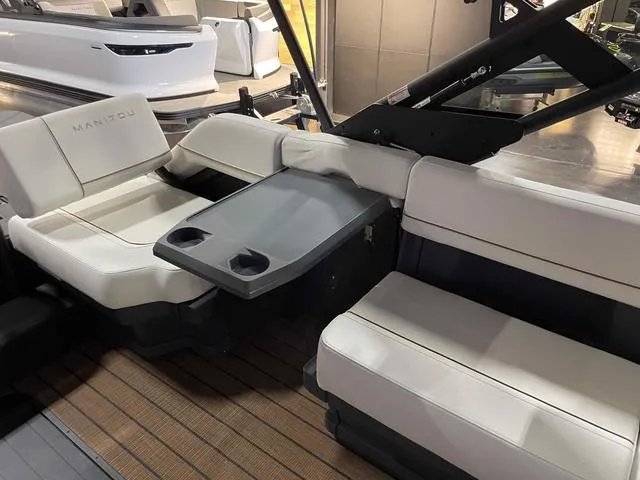 Slide: The Image of 2024 Manitou EXPLORE 24 MAX SGP boat interior with seating and table. - 17