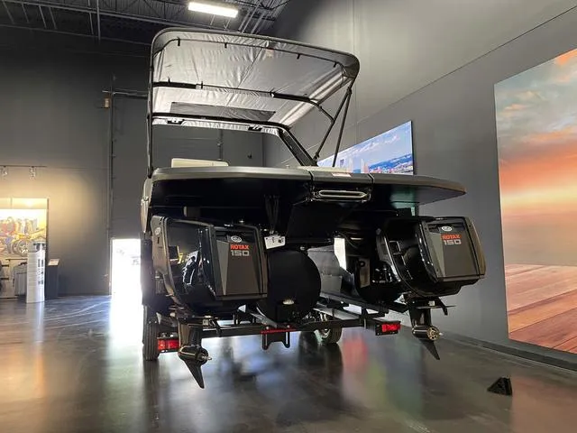 Slide: The Image of 2024 Manitou EXPLORE 24 MAX SGP boat with dual Rotax engines in showroom. - 4