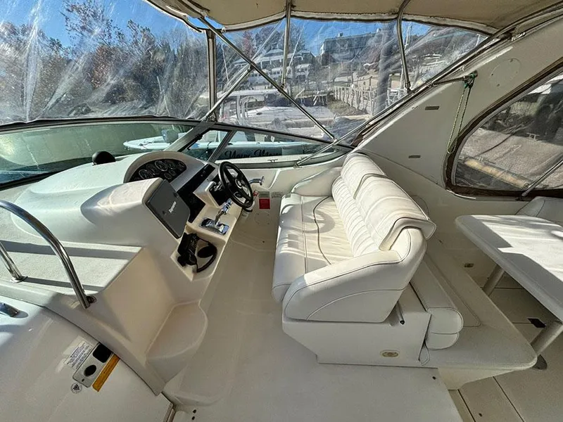 Slide: The Image of 2000 Cruisers Yachts 3375 Express cockpit with white seating and helm controls. - 12