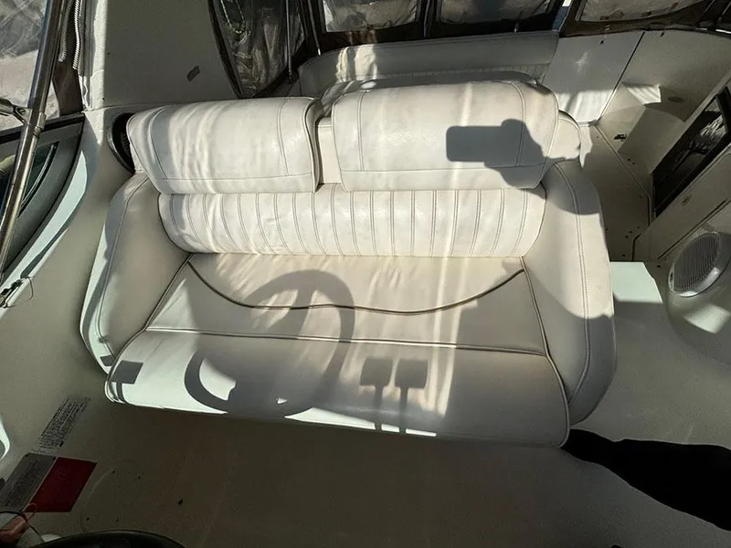 Slide: The Image of Interior seating of 2000 Cruisers Yachts 3375 Express, featuring white leather upholstery. - 13