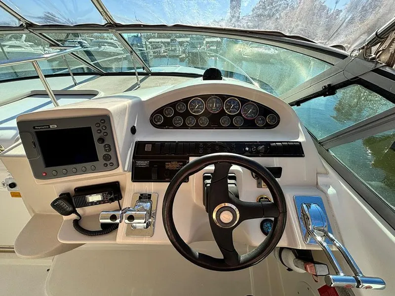 Slide: The Image of 2000 Cruisers Yachts 3375 Express helm with steering wheel and navigation controls. - 14