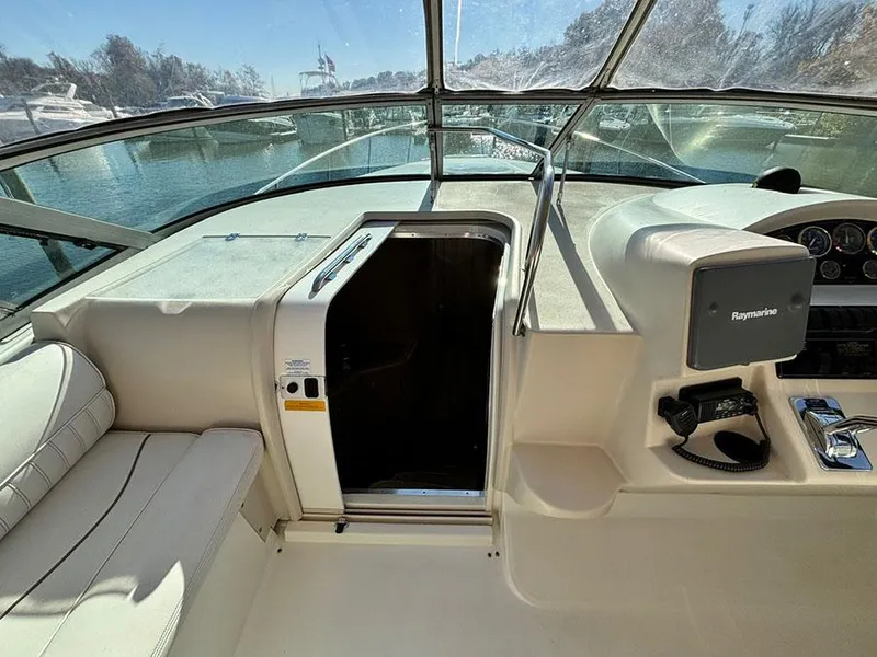 Slide: The Image of 2000 Cruisers Yachts 3375 Express cockpit with helm and seating, overlooking marina. - 17