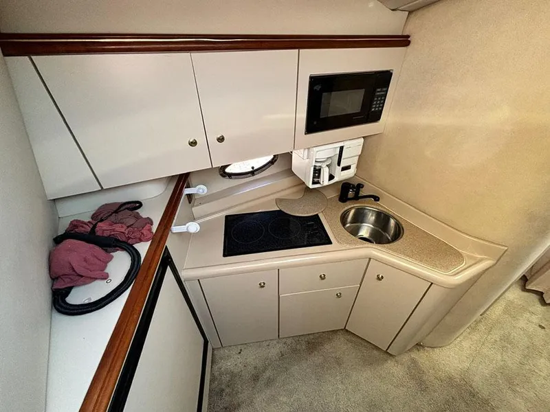 Slide: The Image of 2000 Cruisers Yachts 3375 Express kitchen with microwave, sink, and stove. - 18
