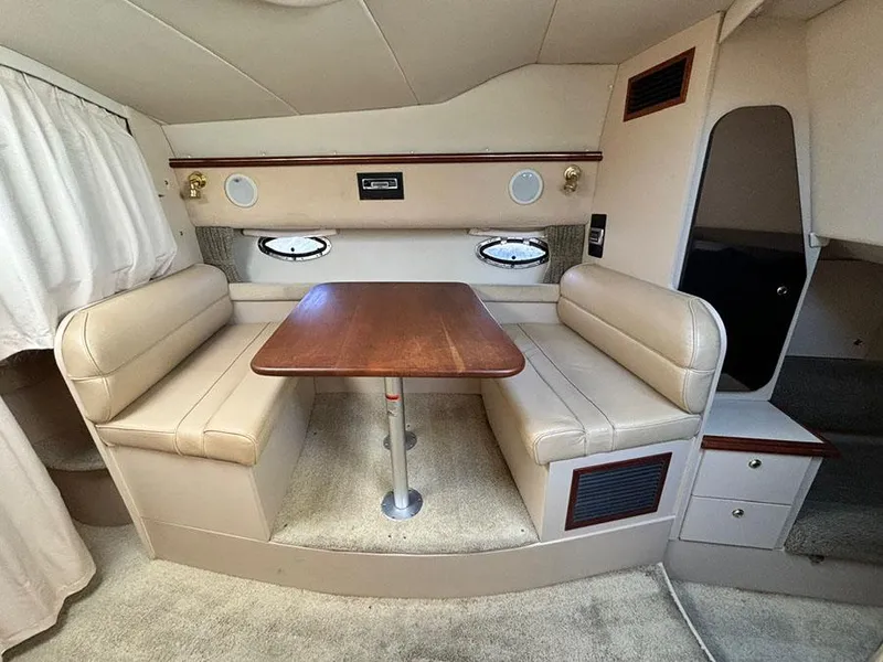 Slide: The Image of Interior of 2000 Cruisers Yachts 3375 Express with beige seating and wooden table. - 20