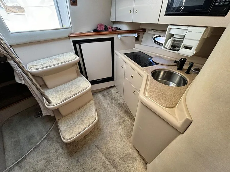Slide: The Image of 2000 Cruisers Yachts 3375 Express interior with kitchenette and stairs. - 21