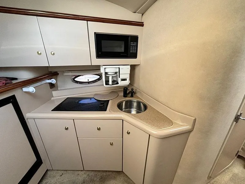 Slide: The Image of 2000 Cruisers Yachts 3375 Express kitchen with microwave, sink, and stove. - 22
