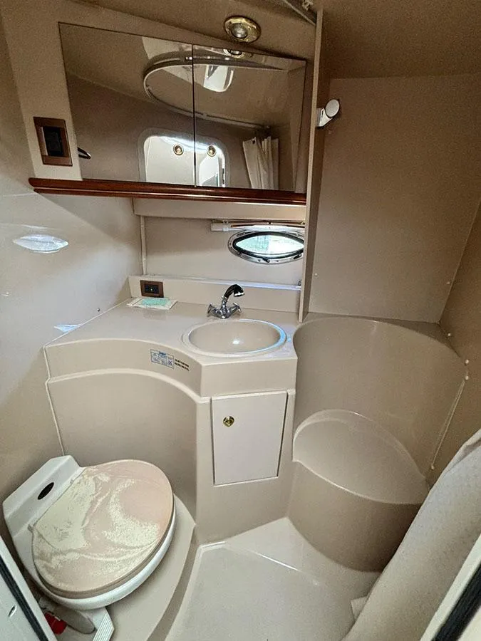 Slide: The Image of 2000 Cruisers Yachts 3375 Express bathroom with sink, mirror, and toilet. - 24