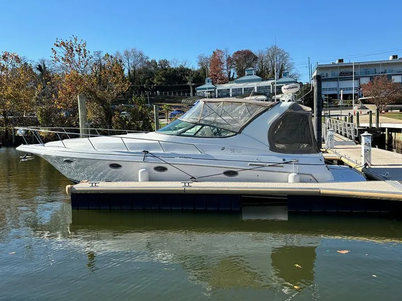 Slide: The Image of 2000 Cruisers Yachts 3375 Express docked in a serene marina setting. - 5
