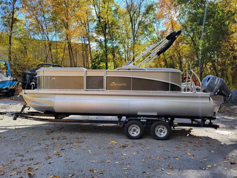 Slide: The Image of 2025 Barletta A20QC pontoon boat on trailer, surrounded by autumn trees. - 11