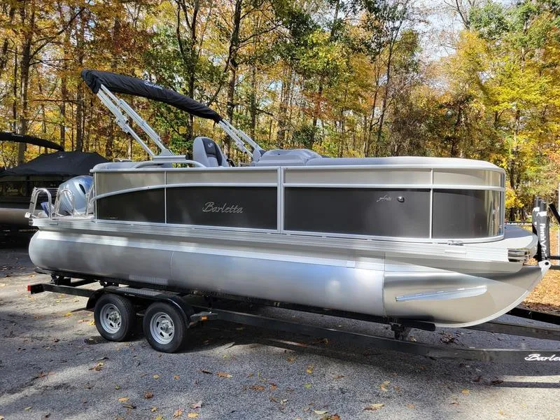Slide: The Image of 2025 Barletta A20QC pontoon boat on trailer, surrounded by autumn trees. - 3