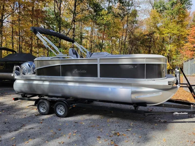 Slide: The Image of 2025 Barletta A20QC pontoon boat on trailer, surrounded by autumn trees. - 4