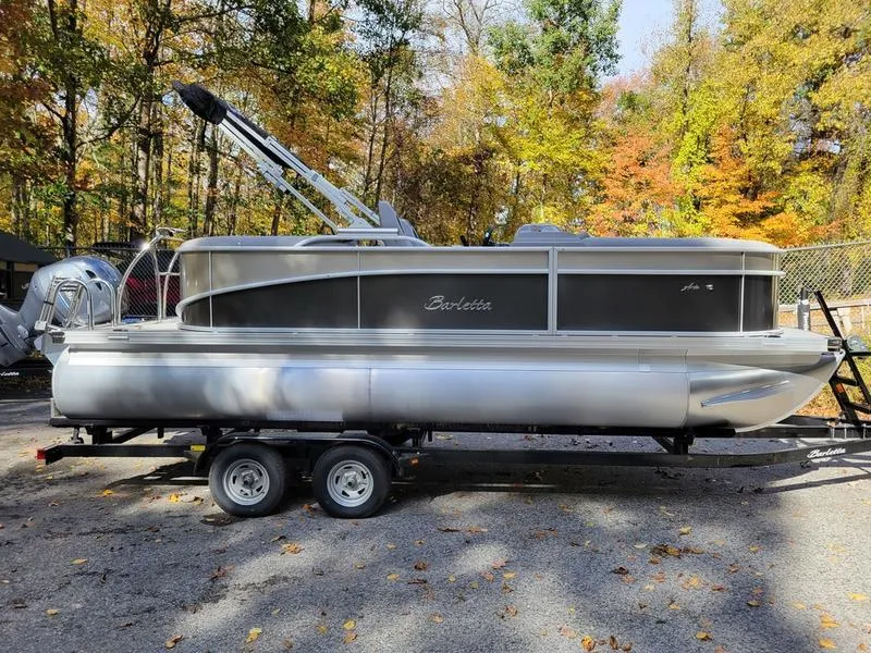 Slide: The Image of 2025 Barletta A20QC pontoon boat on trailer, surrounded by autumn trees. - 5