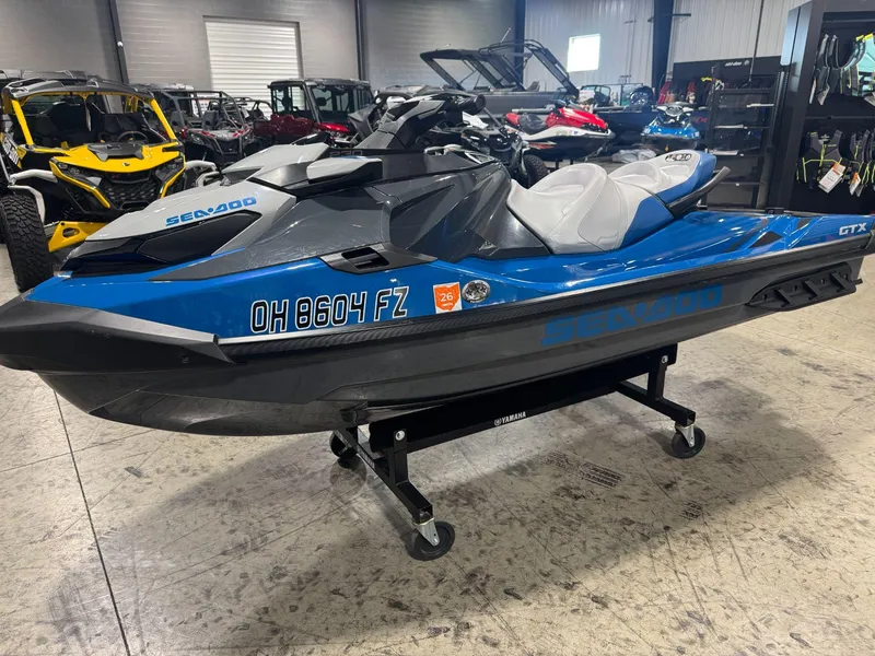 Slide: The Image of 2020 Sea-Doo GTX 230 jet ski in showroom, blue and black design. - 1
