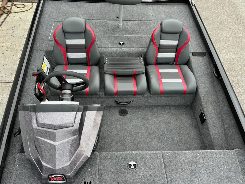 Slide: The Image of 2024 Ranger RT188 boat interior with gray and red seats, steering wheel, and carpeted flooring. - 7