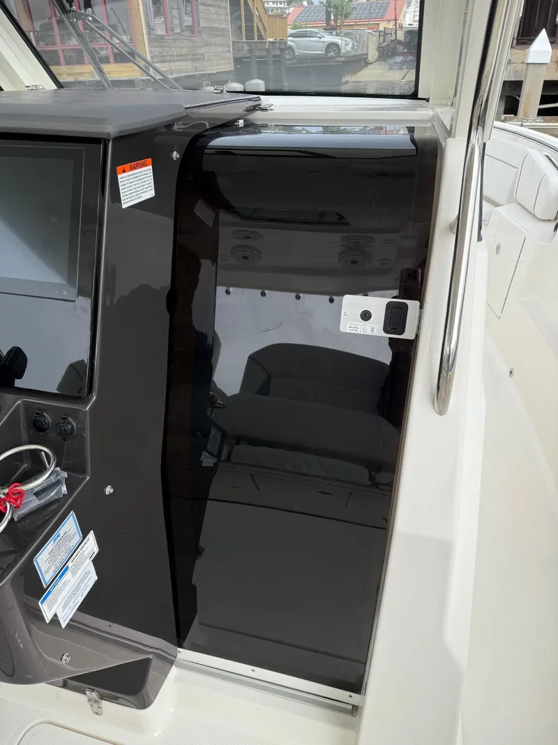 Slide: The Image of 2025 Pursuit S 328 Sport boat interior with sleek black console and modern controls. - 12