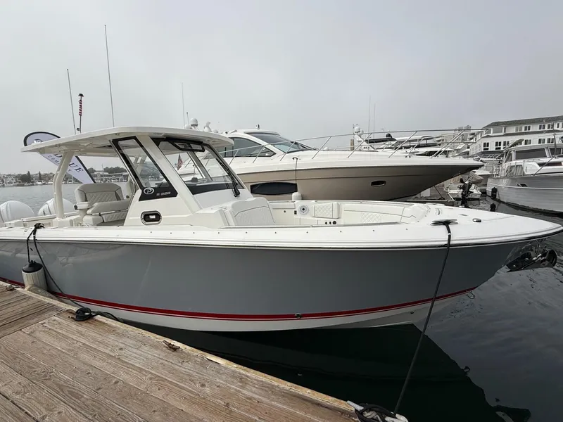 Slide: The Image of 2025 Pursuit S 328 Sport boat docked at marina, overcast sky. - 2