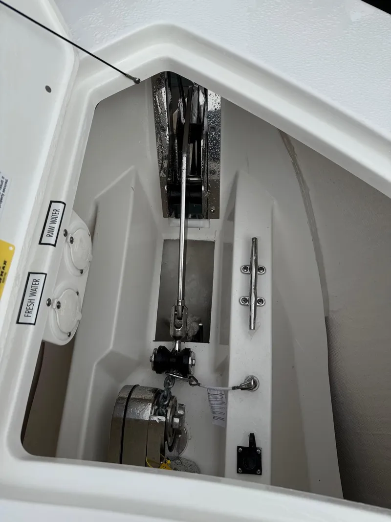 Slide: The Image of 2025 Pursuit S 328 Sport boat anchor compartment with winch and chain. - 21