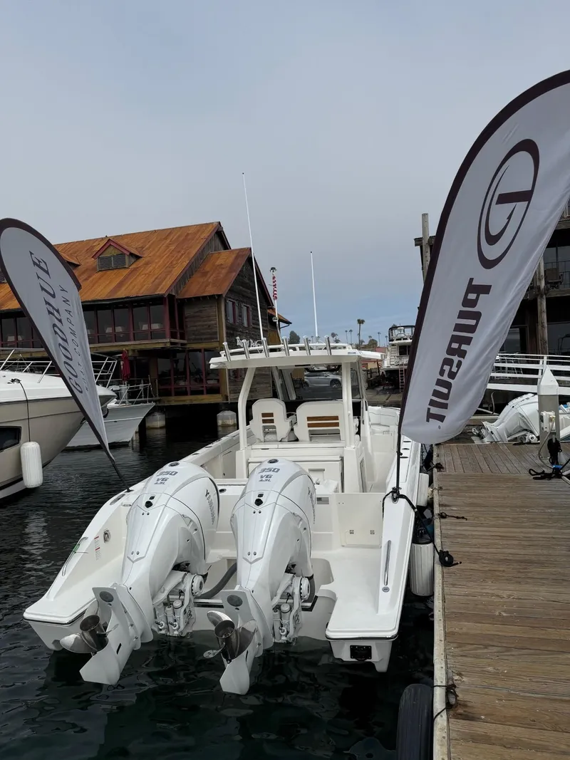 Slide: The Image of 2025 Pursuit S 328 Sport boat docked at marina with flags. - 3