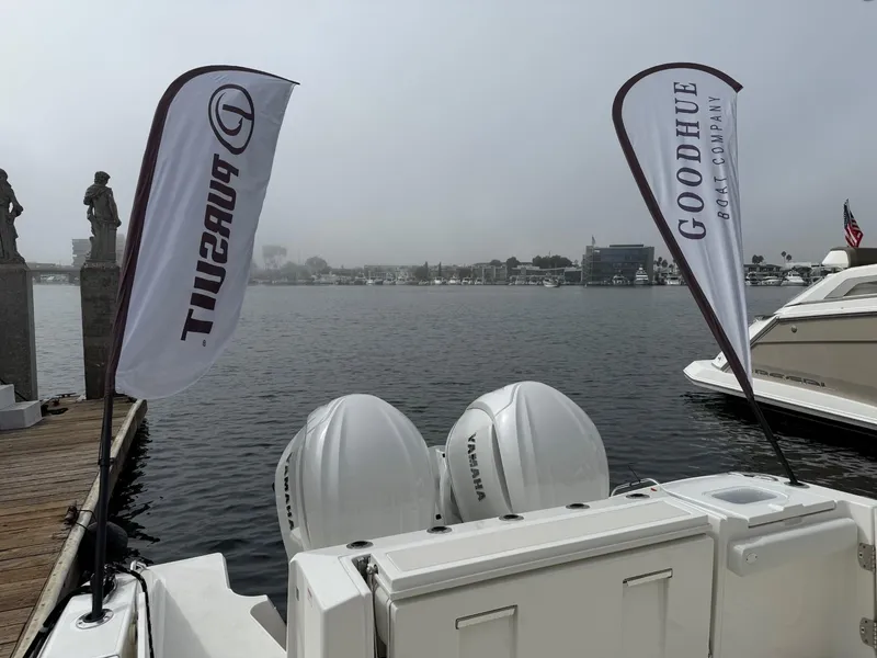 Slide: The Image of 2025 Pursuit S 328 Sport boat docked with Yamaha engines, flags, and waterfront view. - 5