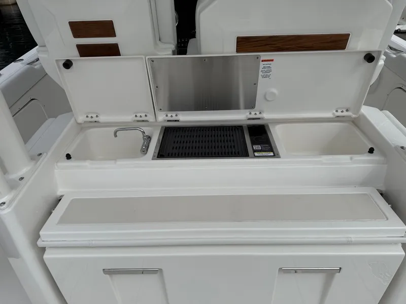 Slide: The Image of 2025 Pursuit S 328 Sport boat interior with sink and storage compartments. - 8