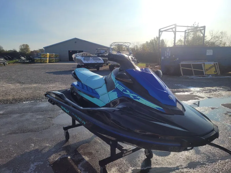 Slide: The Image of 2022 Yamaha WaveRunner EX Deluxe jet ski in a parking lot under sunlight. - 4