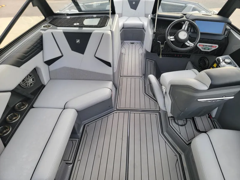 Slide: The Image of Interior of 2022 Nautique Super Air Nautique S21 boat, featuring sleek seating and modern dashboard. - 10