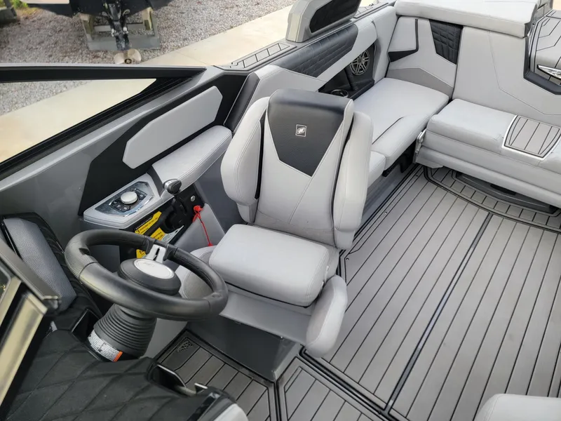 Slide: The Image of Interior of 2022 Nautique Super Air Nautique S21 boat with sleek gray seating and steering. - 9