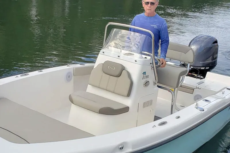 Slide: The Image of 2026 Key West 179 FS boat with outboard motor, parked outdoors. - 2