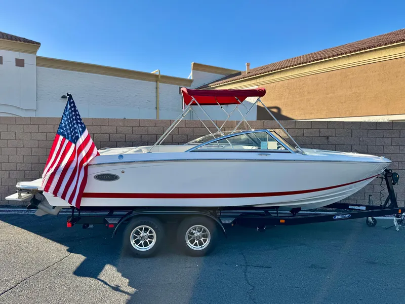 The Image of 2017 Cobalt 220S boat on trailer with American flag, parked outdoors. - 0