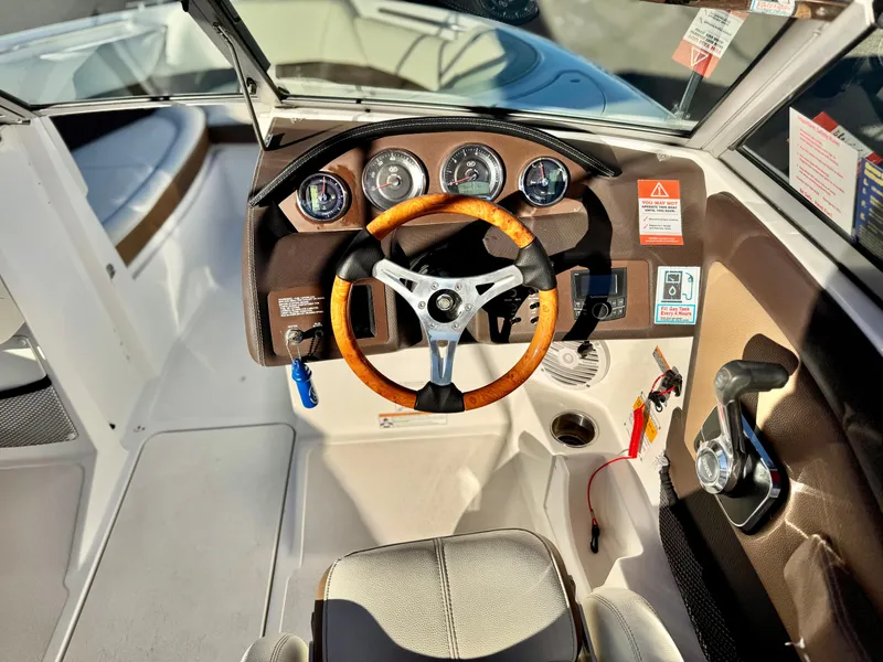 Slide: The Image of 2017 Cobalt 220S boat dashboard with wooden steering wheel and instrument panel. - 24