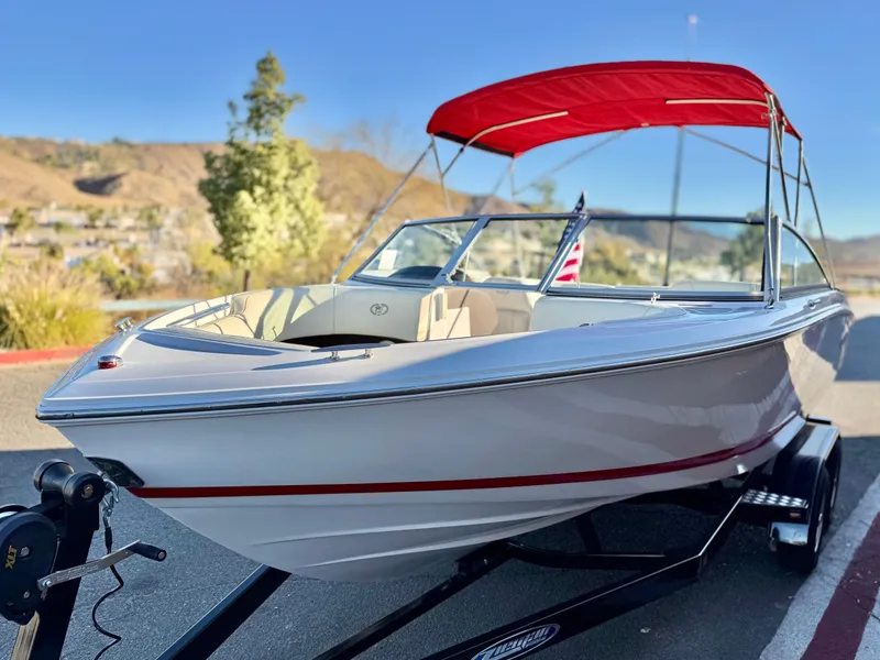 Slide: The Image of 2017 Cobalt 220S boat with red canopy on a trailer, scenic background. - 3
